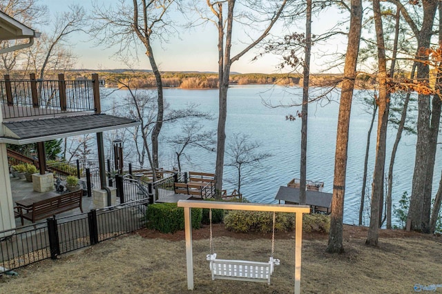 exterior space featuring a water view and fence