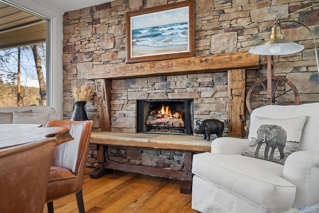 living area with wood finished floors, a fireplace, and crown molding