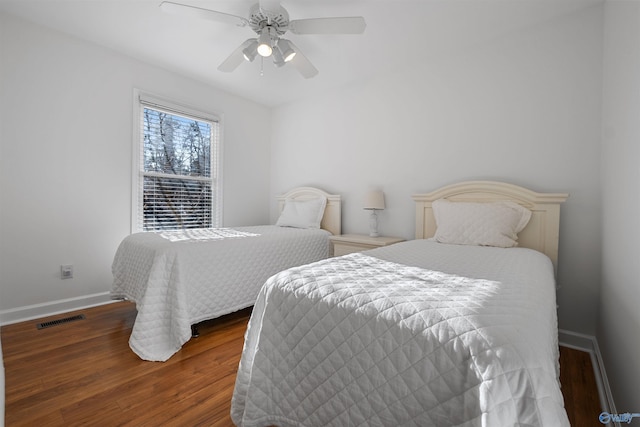 bedroom featuring visible vents, baseboards, wood finished floors, and a ceiling fan