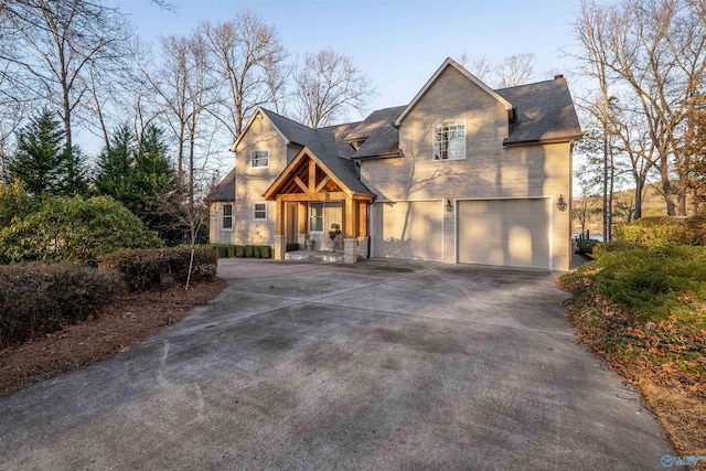 view of front of property featuring a garage, stone siding, roof with shingles, and concrete driveway