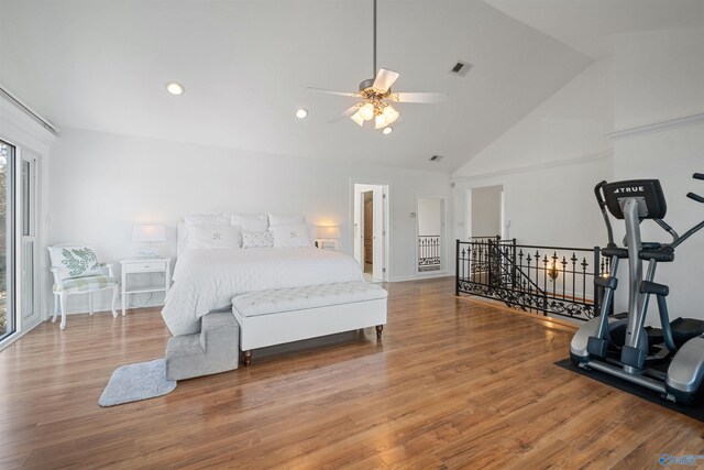 bedroom featuring visible vents, baseboards, high vaulted ceiling, and wood finished floors