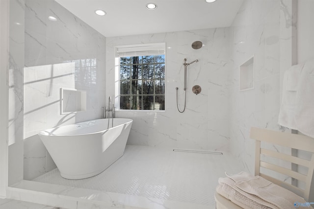 bathroom with a marble finish shower, a freestanding bath, recessed lighting, marble finish floor, and tile walls