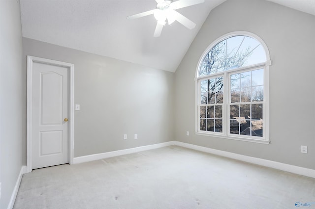 carpeted spare room featuring lofted ceiling, ceiling fan, and baseboards