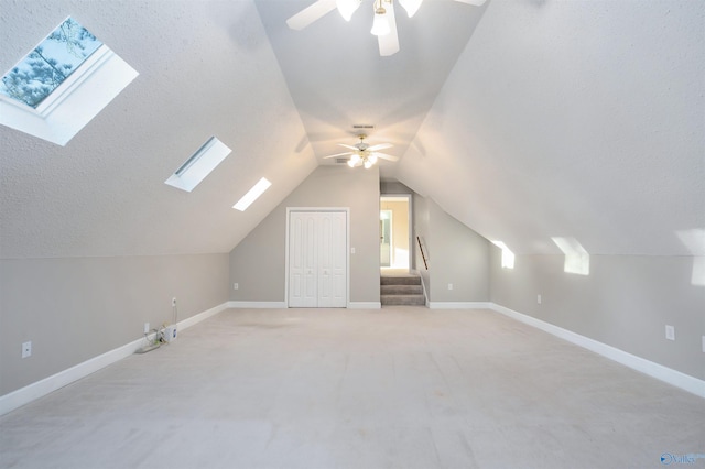 bonus room with baseboards, light colored carpet, ceiling fan, vaulted ceiling, and a textured ceiling