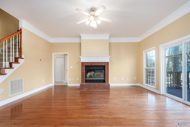 unfurnished living room with crown molding, visible vents, and wood finished floors