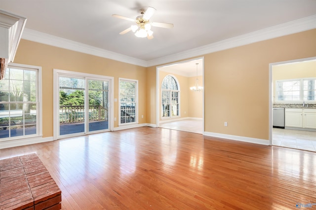 interior space featuring crown molding, ceiling fan with notable chandelier, plenty of natural light, and light wood-style floors