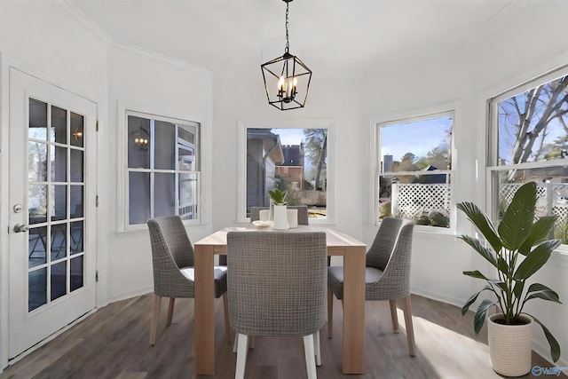 dining area with crown molding, dark hardwood / wood-style floors, and an inviting chandelier