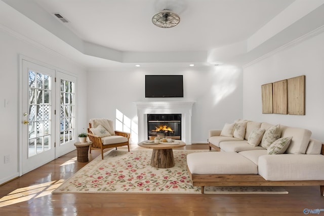 living room featuring french doors, crown molding, and hardwood / wood-style floors