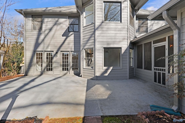 rear view of house featuring a sunroom and a patio area