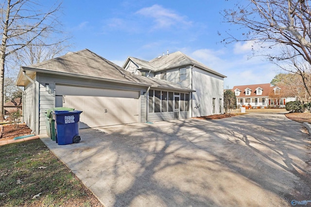 view of side of property featuring a garage and a sunroom