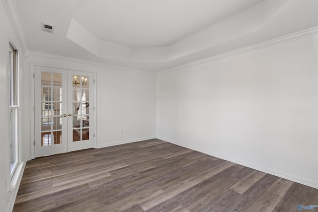 spare room featuring french doors, ornamental molding, dark hardwood / wood-style floors, and a raised ceiling