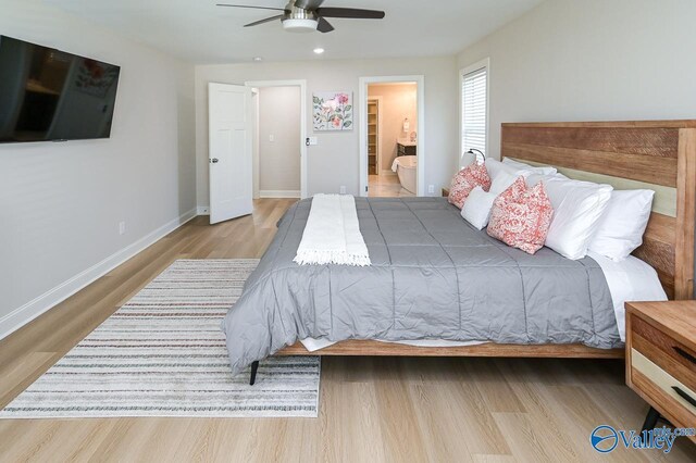 bedroom featuring ensuite bath, light hardwood / wood-style flooring, and ceiling fan