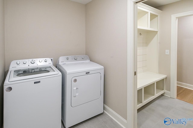 laundry room featuring washer and clothes dryer and light hardwood / wood-style floors