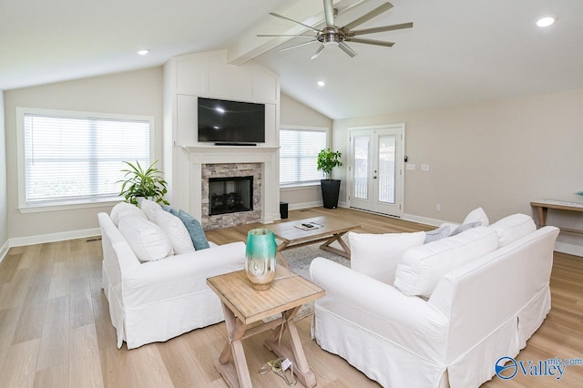 living room featuring ceiling fan, french doors, lofted ceiling with beams, light hardwood / wood-style floors, and a fireplace