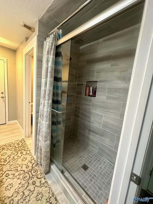 173 N Seneca Dr, Trinity, AL 35673 - bathroom featuring a shower stall, a textured ceiling, and toilet