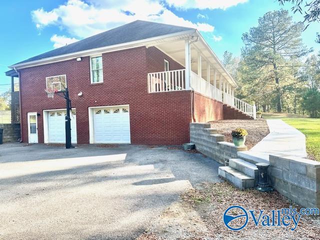 173 N Seneca Dr, Trinity, AL 35673 - view of property exterior with a garage, driveway, and brick siding