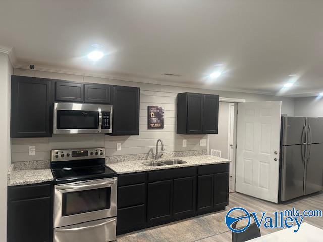 173 N Seneca Dr, Trinity, AL 35673 - kitchen with stainless steel appliances, a sink, dark cabinets, and ornamental molding