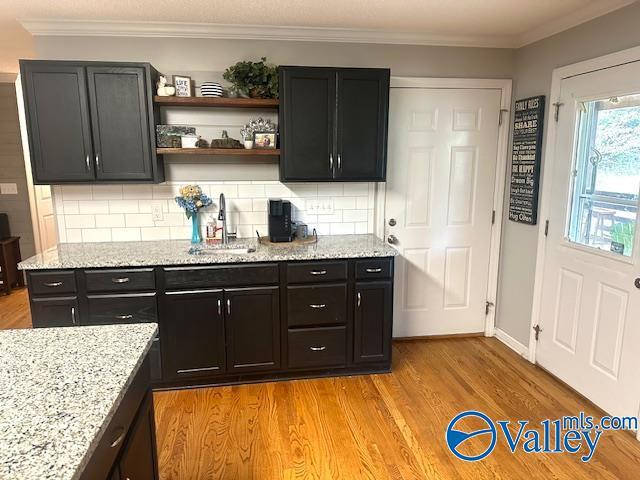173 N Seneca Dr, Trinity, AL 35673 - kitchen with a sink, decorative backsplash, light stone counters, light wood-style floors, and crown molding