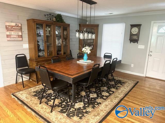 173 N Seneca Dr, Trinity, AL 35673 - dining space featuring wood finished floors, ornamental molding, and wooden walls