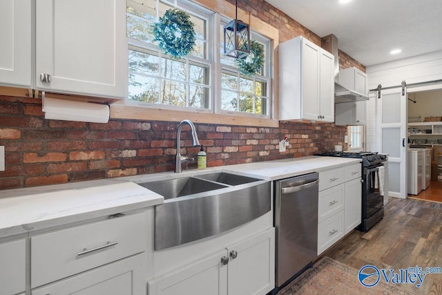 kitchen with a barn door, gas range, stainless steel dishwasher, white cabinets, and sink