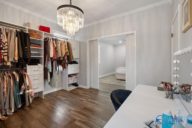 walk in closet with dark wood-type flooring and a notable chandelier