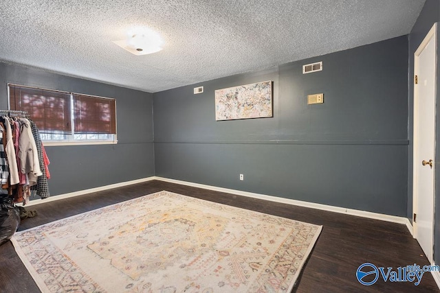 interior space featuring dark hardwood / wood-style floors and a textured ceiling