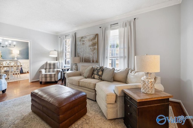 living room featuring a textured ceiling, an inviting chandelier, crown molding, and light hardwood / wood-style floors