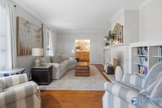 living room featuring baseboard heating, light wood-type flooring, and crown molding