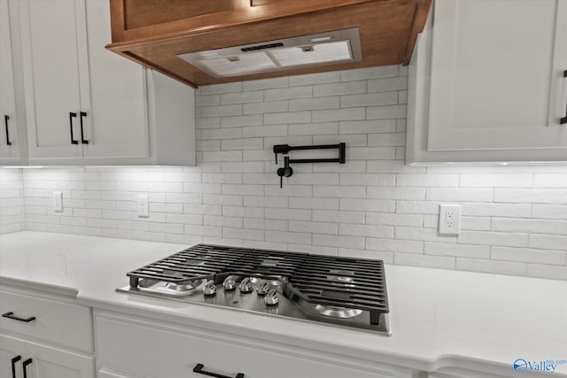22692 Gunner Cir, Athens, AL 35613 - kitchen featuring stainless steel gas stovetop, light countertops, white cabinetry, and decorative backsplash