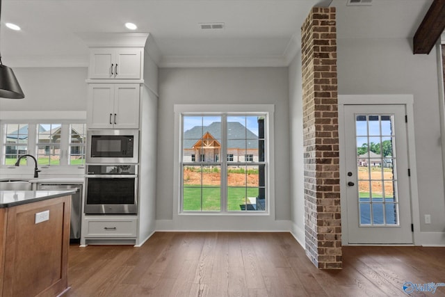 22692 Gunner Cir, Athens, AL 35613 - kitchen featuring stainless steel appliances, wood finished floors, white cabinetry, healthy amount of natural light, and recessed lighting