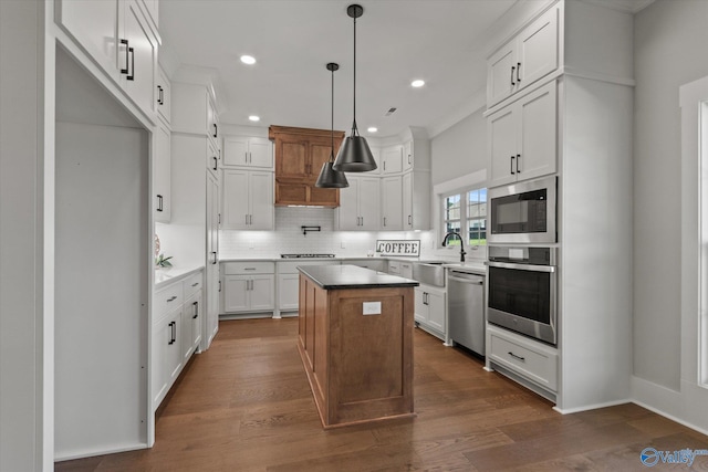 22692 Gunner Cir, Athens, AL 35613 - kitchen with appliances with stainless steel finishes, a sink, backsplash, a kitchen island, and dark wood-type flooring