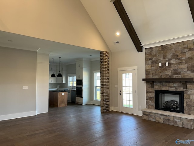 22692 Gunner Cir, Athens, AL 35613 - unfurnished living room featuring a stone fireplace, high vaulted ceiling, baseboards, dark wood-style flooring, and beamed ceiling