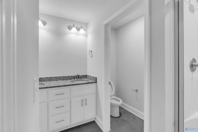 bathroom with toilet, baseboards, and vanity