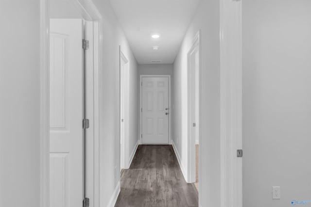 hall with baseboards and wood finished floors