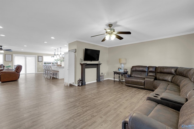 living room featuring light hardwood / wood-style flooring, ornamental molding, and ceiling fan