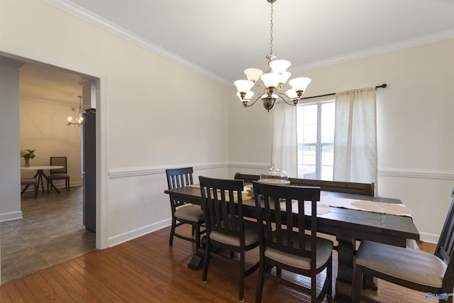 dining space with dark hardwood / wood-style floors, ornamental molding, and a chandelier