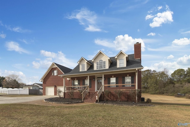 view of front of house with a front lawn, covered porch, and a garage