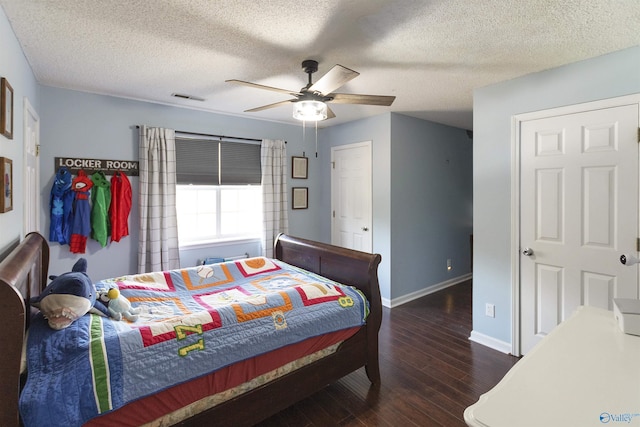 bedroom featuring ceiling fan, dark wood-type flooring, and a textured ceiling