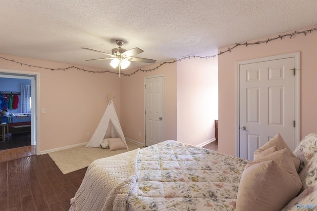 bedroom featuring ceiling fan, dark wood-type flooring, and a textured ceiling