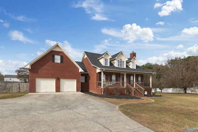 view of front of property featuring covered porch, a garage, and a front lawn