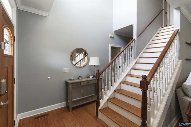 entryway with hardwood / wood-style flooring and crown molding