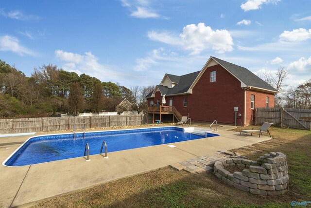 view of swimming pool with a patio, an outdoor fire pit, and a wooden deck