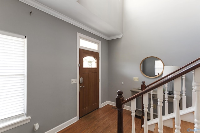 entrance foyer with ornamental molding and dark wood-type flooring