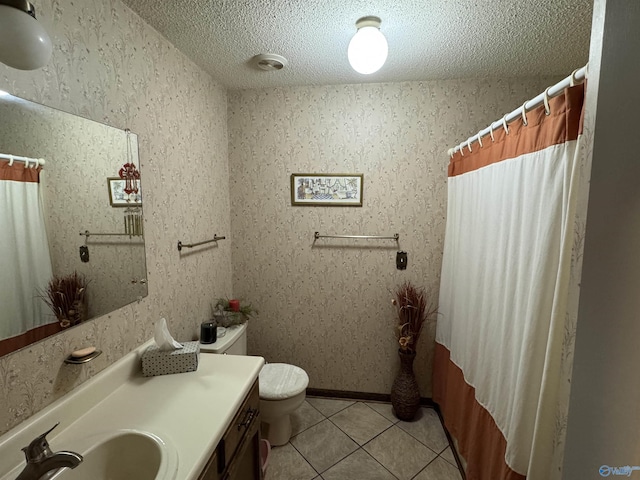 bathroom featuring vanity, baseboards, tile patterned flooring, a textured ceiling, and toilet
