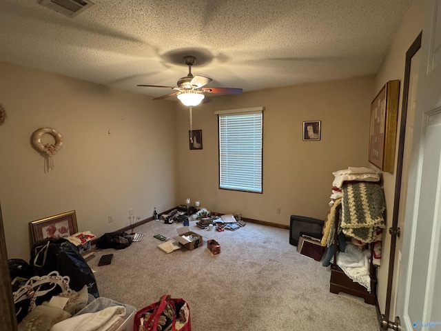 unfurnished bedroom featuring visible vents, baseboards, ceiling fan, carpet, and a textured ceiling