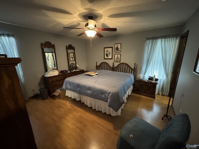 bedroom featuring a textured ceiling, a ceiling fan, and wood finished floors