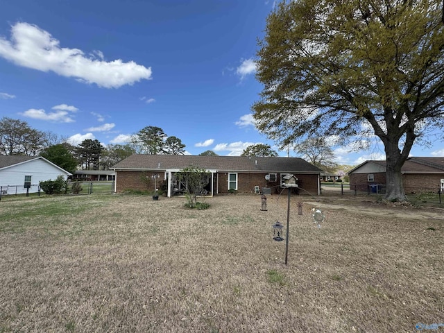 view of front of property with brick siding, fence, and a front lawn