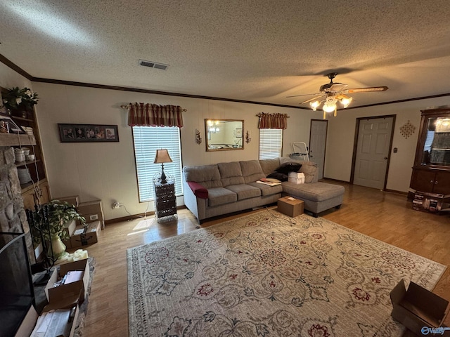 living area featuring crown molding, visible vents, ceiling fan, and wood finished floors