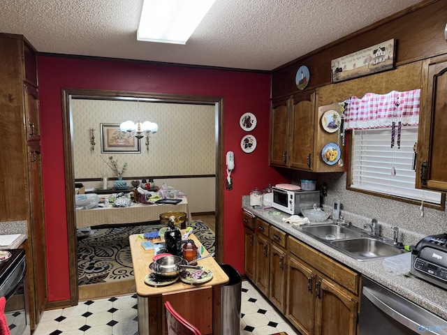 kitchen featuring a toaster, a textured ceiling, light floors, dishwasher, and a sink