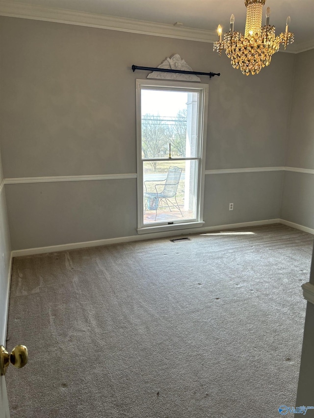 carpeted empty room featuring ornamental molding and a chandelier